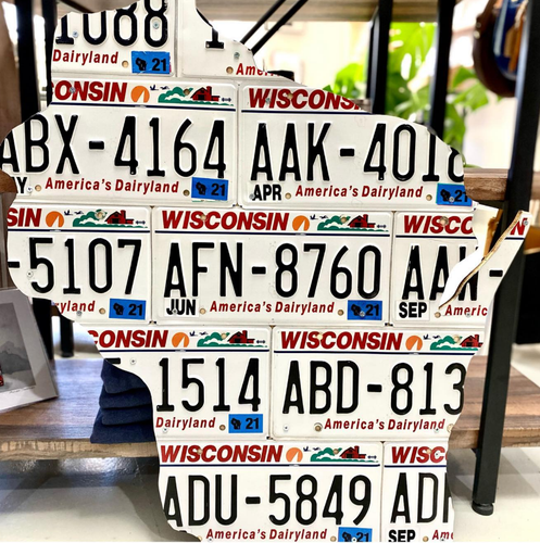 A collection of Wisconsin license plates displayed in a grid pattern, featuring a variety of numbers and colors, with 'Wisconsin' and 'Dairyland' text visible.